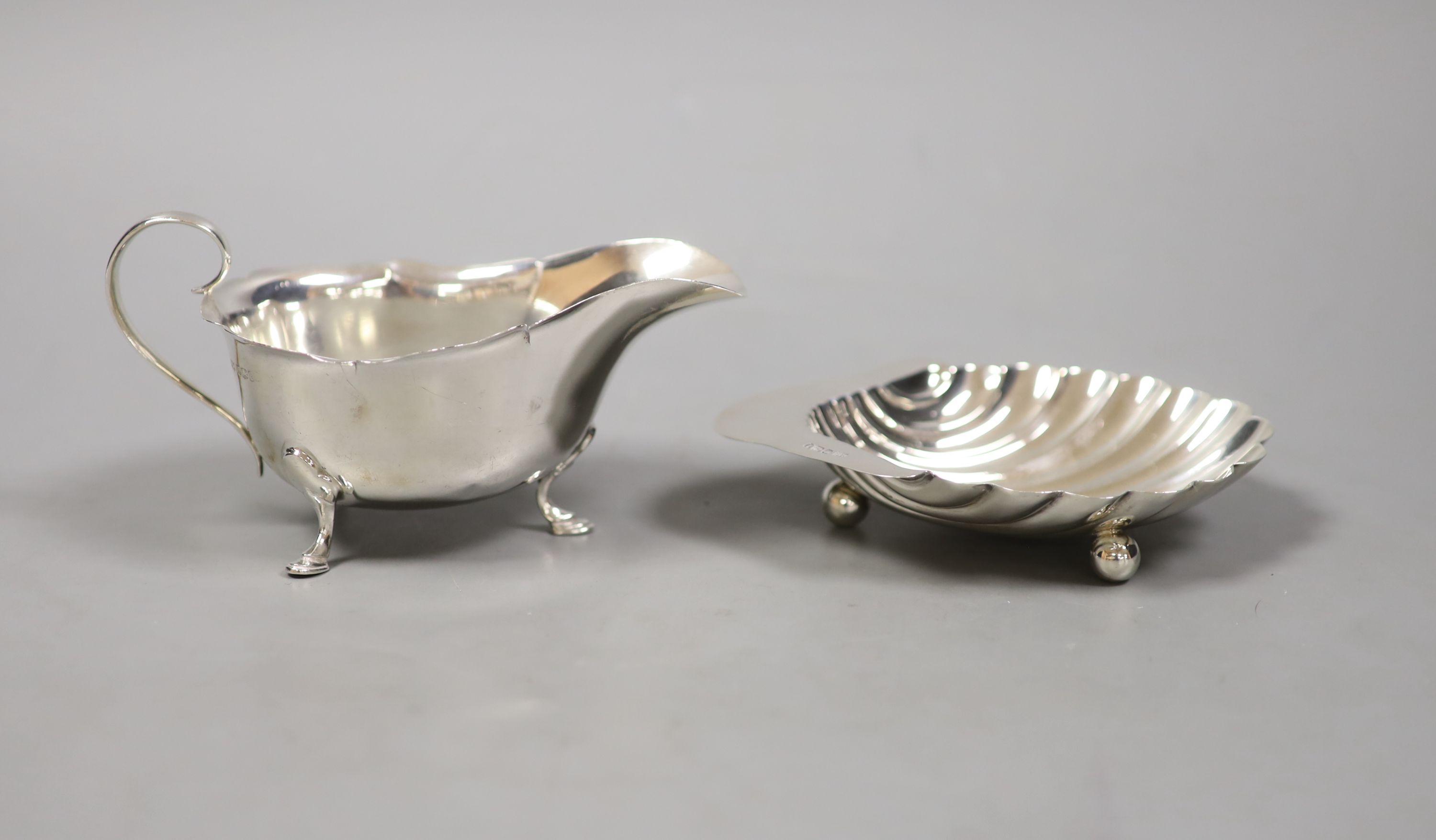 A George V silver butter shell, 13.2cm and a similar sauceboat by Mappin & Webb